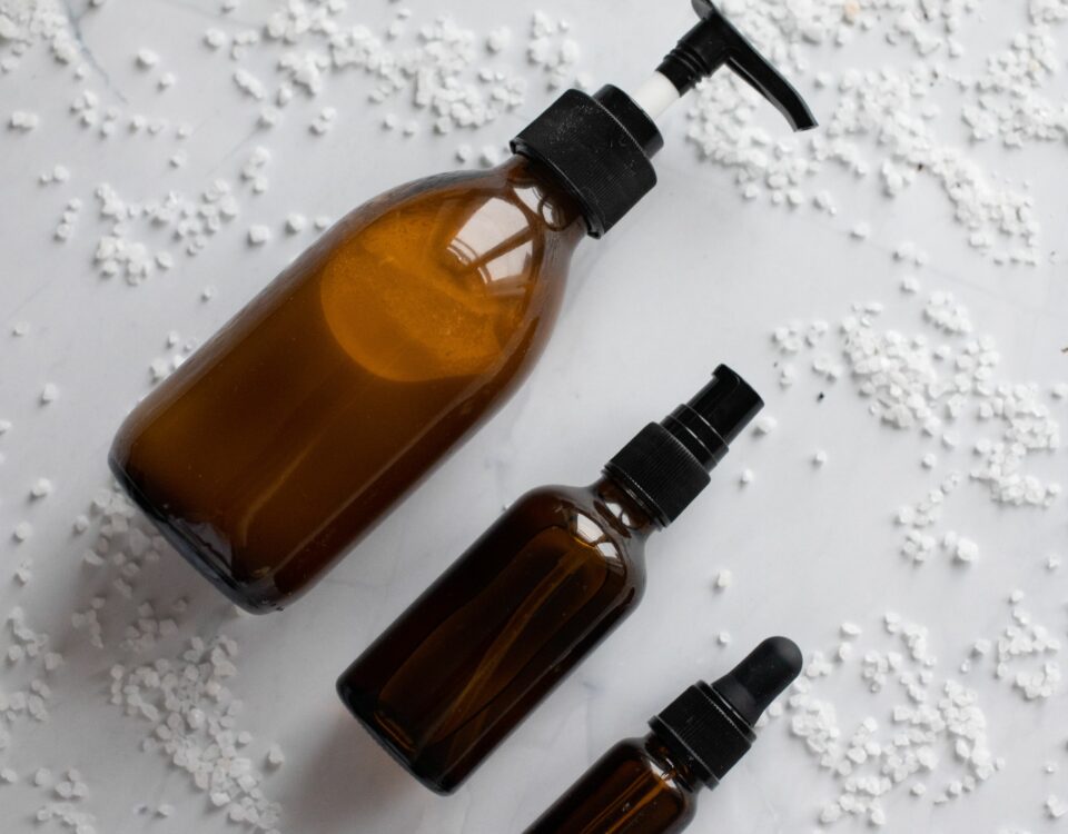 Black Friday beauté 2026 : trois flacons ambrés de soin posés sur du marbre blanc