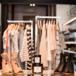 Lancer une marque de beauté depuis la mode : pots de soin et chaussures devant les portants d'une boutique de prêt-à-porter